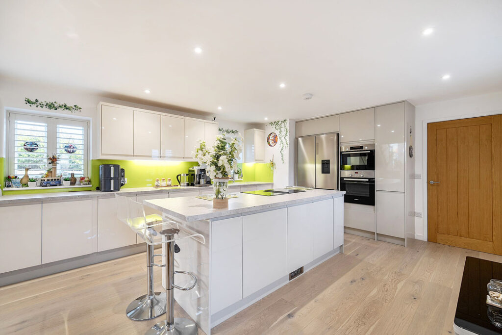 Wide view of modern luxury kitchen with island in white and grey.