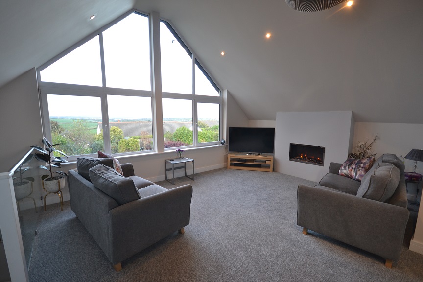 A beautful large lounge with a huge a frame shaped large picture window but looking dark and drab and washed out by the window brightness