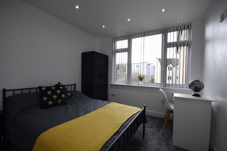 A dark bedroom, with a bright window
