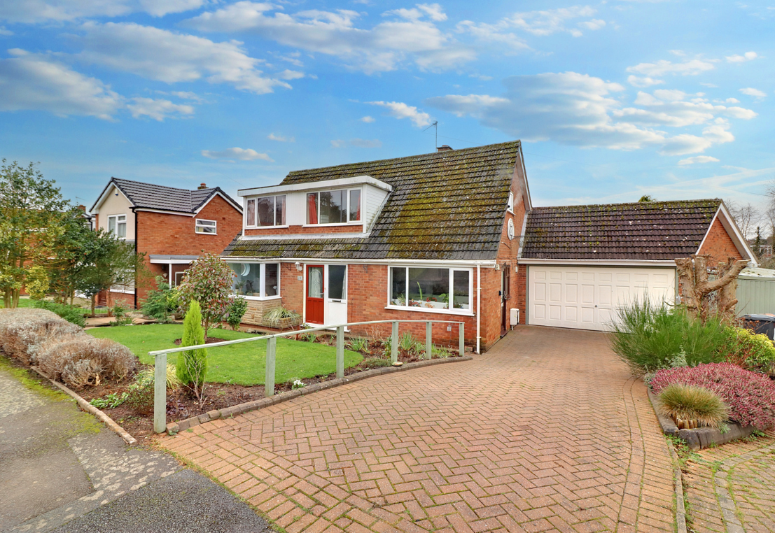 The enhanced An exterior shot of an extended bungalow from the kerb showing the drive but looking fabulous under bright blue skies with natural colour correction