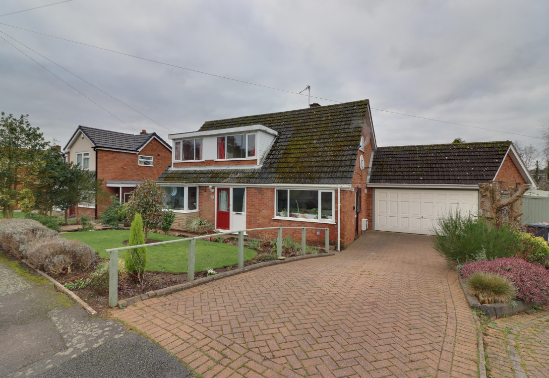 An exterior shot of an extended bungalow from the kerb showing the drive but looking drab under grey skies