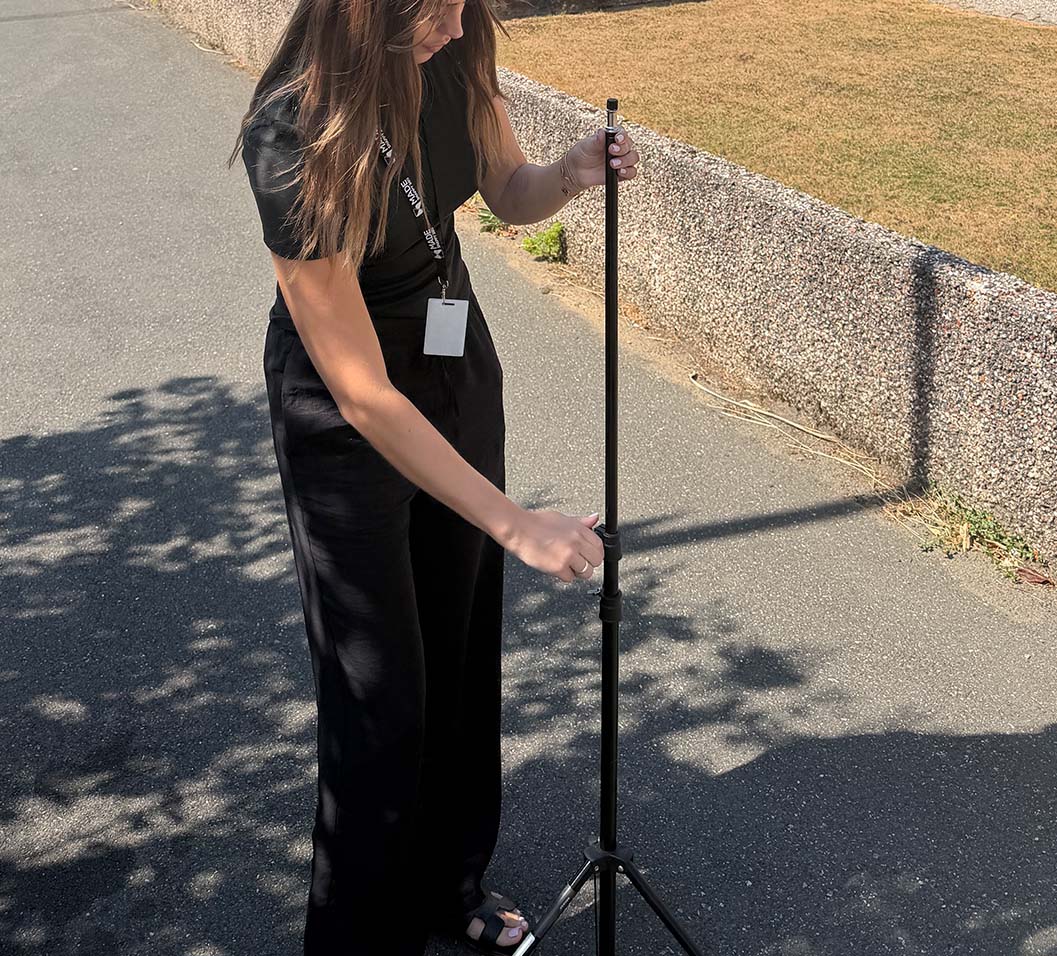 Estate agent setting up a tripod for a camera.